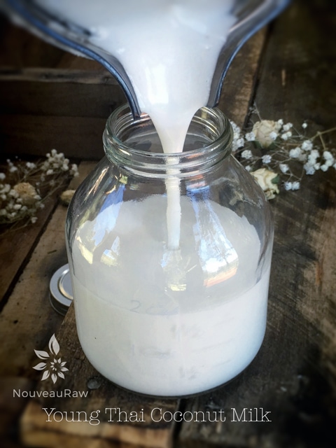 pouring raw vegan young Thai coconut milk into a milk jug