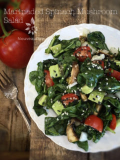 raw vegan Marinaded Wilted Spinach Mushroom Salad served on a white plate