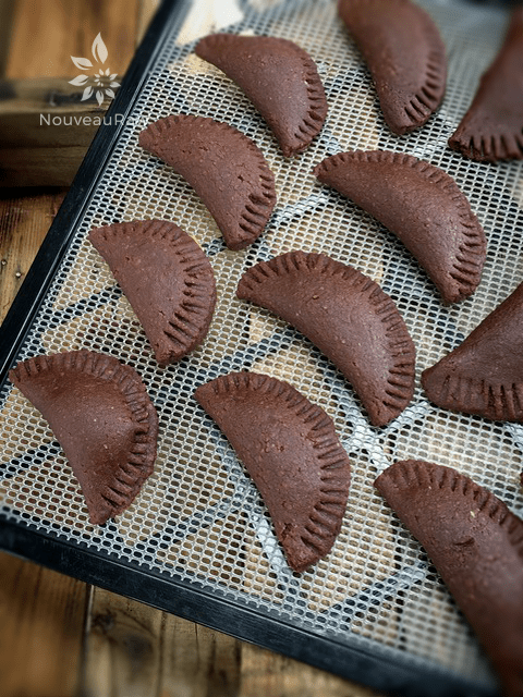 the raw vegan gluten-free Chocolate Pastry Empanadas placed on the dehydrator tray to dry