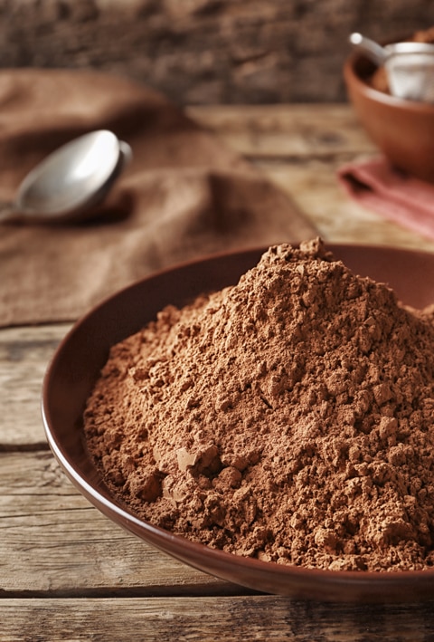 cacao-powder piled in a wooden bowl