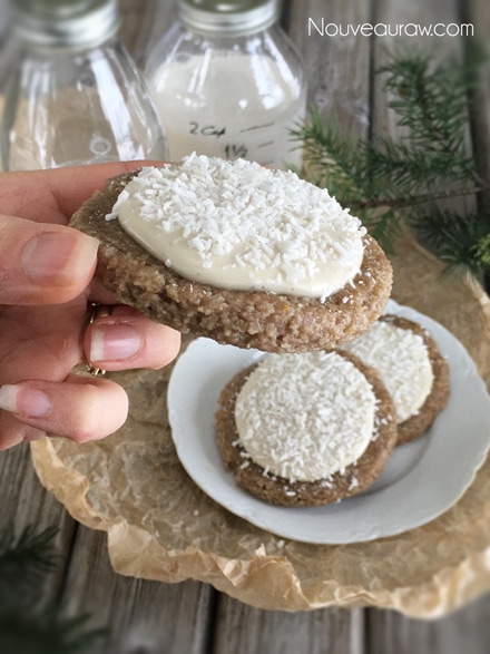 a white plate of raw vegan Frosted Orangesicle Sugar Cookies with shredded coconut on top