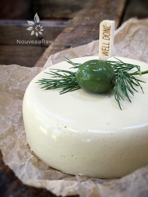 vegan gluten-free vegan Onion Dill & Horseradish Cheese wheel with a green olive on top