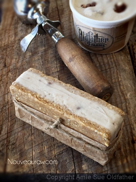 Peanut Butter Chocolate Chip Ice Cream Sandwiches displayed on barn wood with an antique ice cream scoop