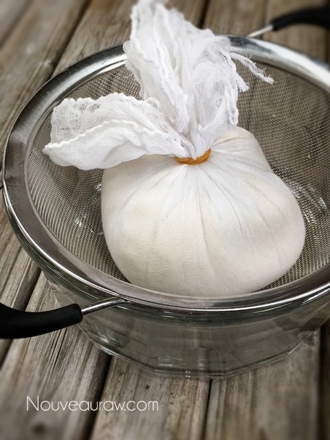 placing the Almond Cheese in cheesecloth, gather it up and keep it closed with a rubber band