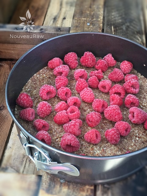 After pressing the crust into the pan, place the raspberries on top.