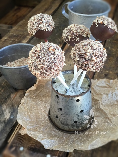 Chocolate covered peanut butter balls drying in antique cheese press colander
