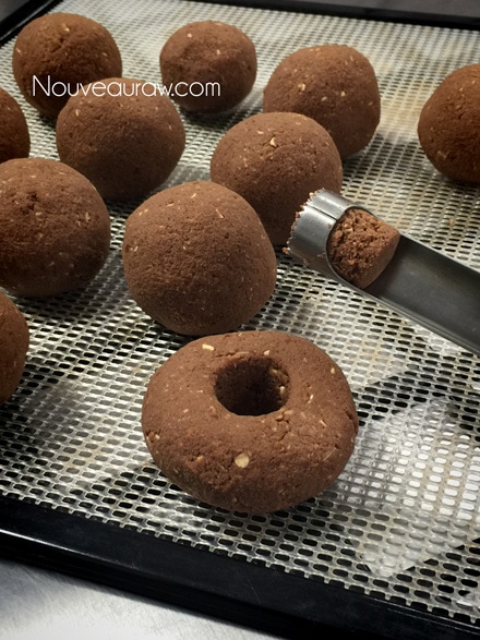 removing the core of the raw vegan gluten-free Double Chocolate Cake Doughnuts