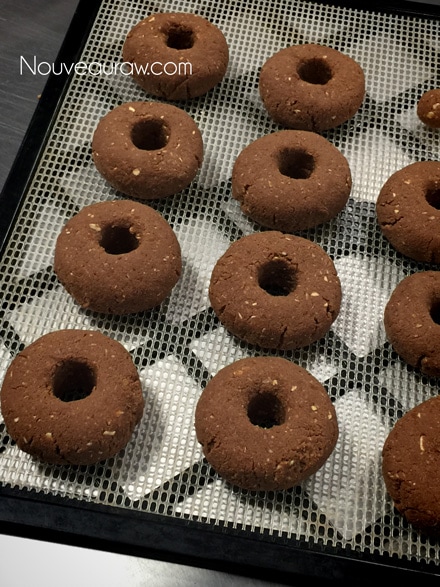 laying the raw vegan gluten-free Double Chocolate Cake Doughnuts on a dehydrator sheet