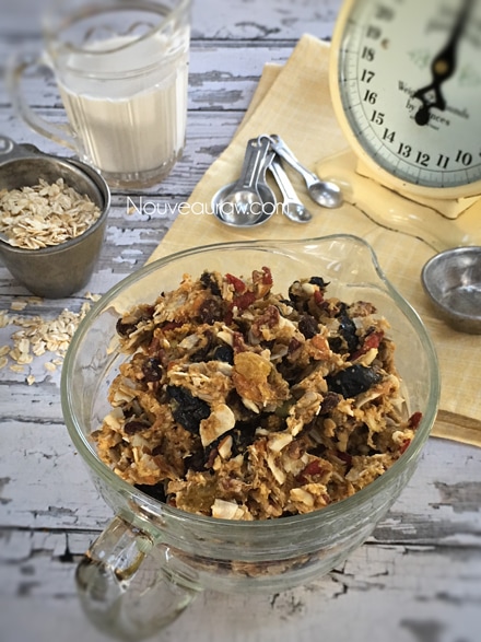 an over view of raw gluten-free Fruitcake Granola displayed in an antique measuring cup 