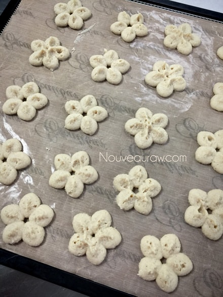 over view of using a cookie press to make raw vegan gluten free Cashew Lemon Spritz Cookies 