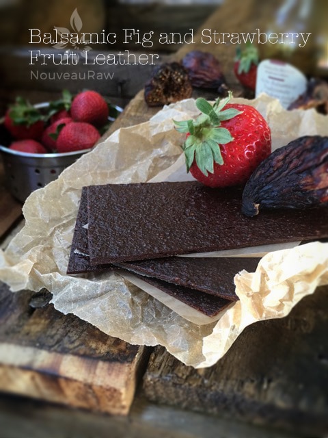 raw Balsamic Fig and Strawberry Fruit Leather displayed on a wooden table with fresh strawberries