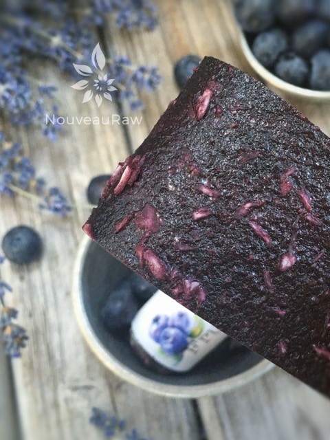 a close up of raw Blueberry Coconut Fruit Leather displayed with fresh blueberries and dried lavender 