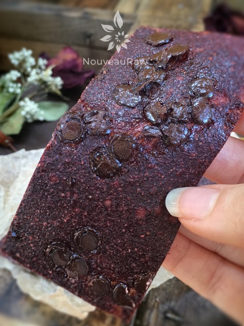 a close up of raw Chocolate Strawberry Fruit Leather displayed with dried red roses