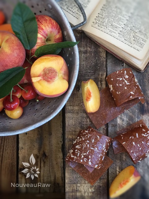 an over view of Paradise Sweet Almond Fruit Leather displayed with fresh peaches from the orchard