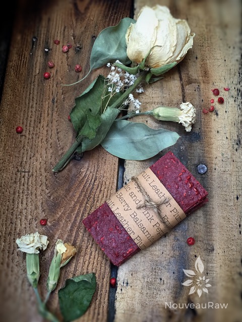 raw sugar free Plum-Berry Balsamic and Pink Peppercorn Fruit Leather displayed with a dried rose