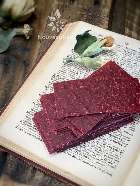 a close up raw sugar free sweet and tart Sassy Raspberry Banana Fruit Leathers displayed on an antique dictionary