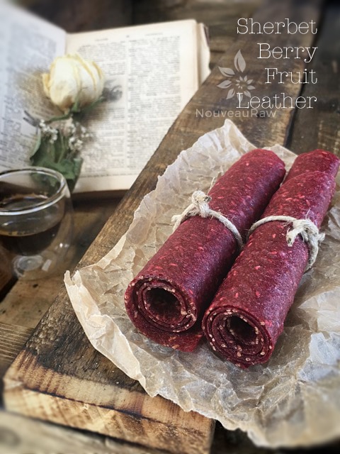 raw sugar free Sherbet-Berry Fruit Leather rolled up on a piece of barn wood
