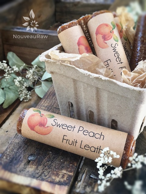 Sweet Peach Fruit Leather rolled in plastic wrap with a handmade label attached 