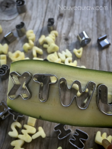 close up of creating zucchini letters with cookie cutters