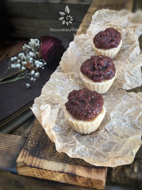 mouthwatering raw, gluten-free Cherry Coconut Thumbprints displayed on parchment paper