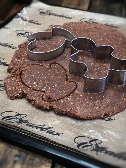 using cookie cutters to shape the raw vegan gluten-free Gingerbread Tea Brownies shaped as mittens