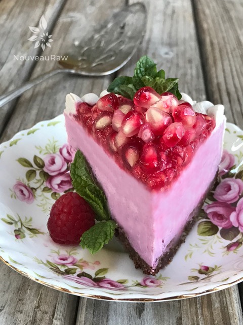 a close up decorated raw vegan pomegranate lemon cheesecake