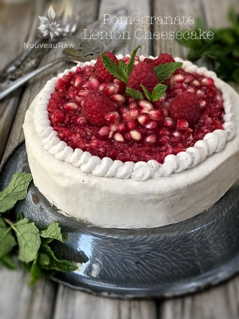 Pomegranate Lemon Cheesecake displayed on a wooden table and fresh mint