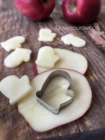 using cookie cutters to cut shapes of apple out with