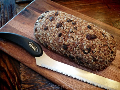 Raw Gluten-Free Seed Of Life Bread on a Board with a knife