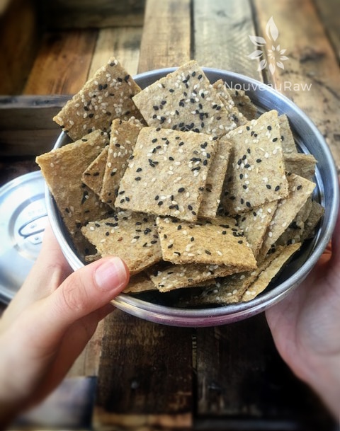 a close up of raw gluten free Caramelized Onion Crackers displayed with me holding a bowl of them