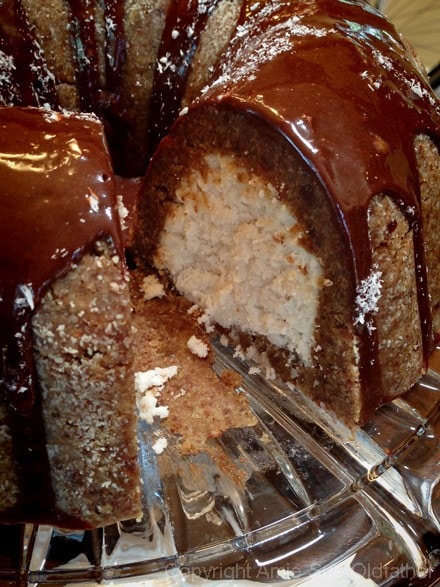 A delicious slice of Raw Gluten-Free Almond Cardamon Bundt Cake with chocolate ganache on top