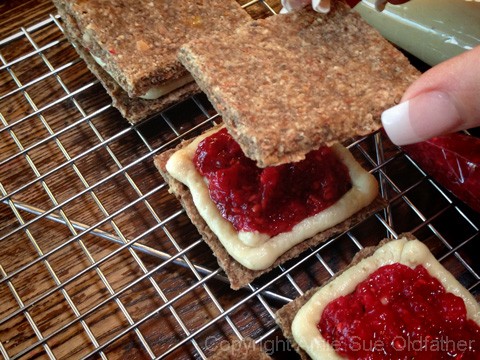 putting together the vegan gluten free Peanut Butter and Jelly Cracker Sandwiches 