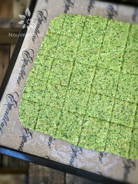 spreading the batter of raw gluten free Arugula and Sunflower Seed Crackers on an Excalibur dehydrator tray