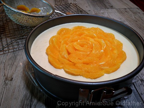 Placing the oranges top of the Raw Gluten-free Creamsicle Cheesecake, like a flower