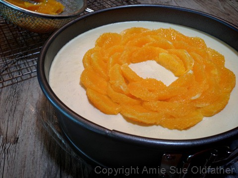 Placing the oranges top of the Raw Gluten-free Creamsicle Cheesecake 