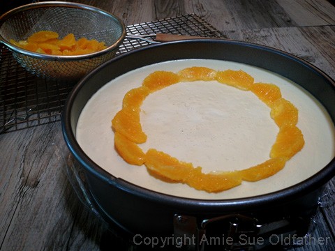 Decorating top of the Raw Gluten-free Creamsicle Cheesecake with oranges 