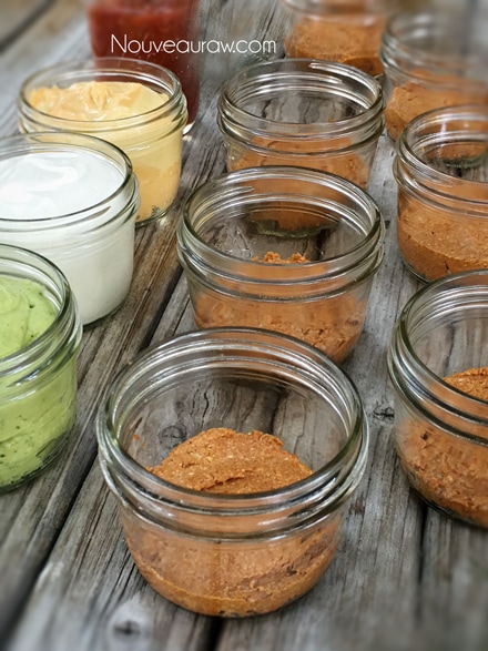 layering in the ingredients when making raw vegan Five Layer Mexican Fiesta Dip