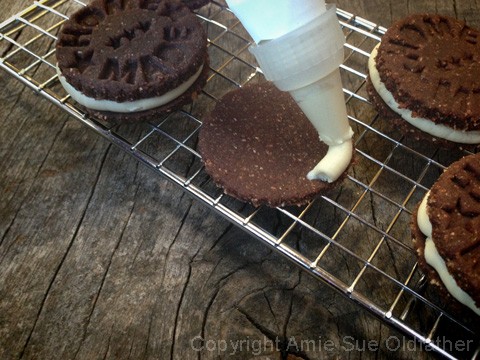 piping the icing onto the Chocolate and Cream Sandwich Cookies