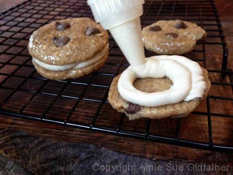 piping the icing on the raw vegan Chocolate Chip and Espresso Buttercream Sandwich Cookies