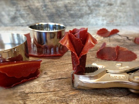 making layers of peddles for the raw Fruit Leather Flowers using a set of pliers to hold them