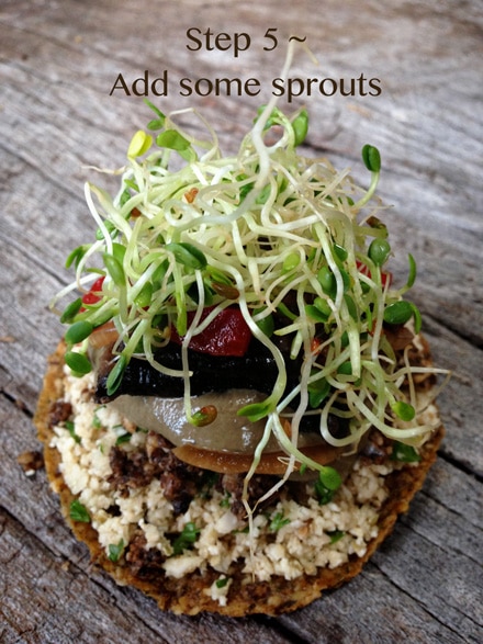 piling on some sprouts to the raw vegan gluten-free Bob's Raw Gypsy Burger 