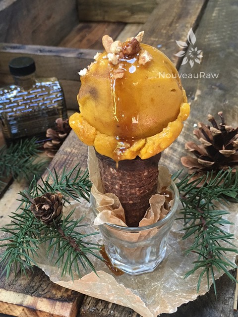 raw dairy free Pumpkin Spice Banana Ice Cream in a raw gluten free cone with maple syrup on top