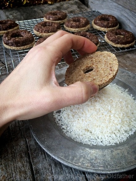 dipping the raw vegan gluten-free Caramel deLights into shredded coconut