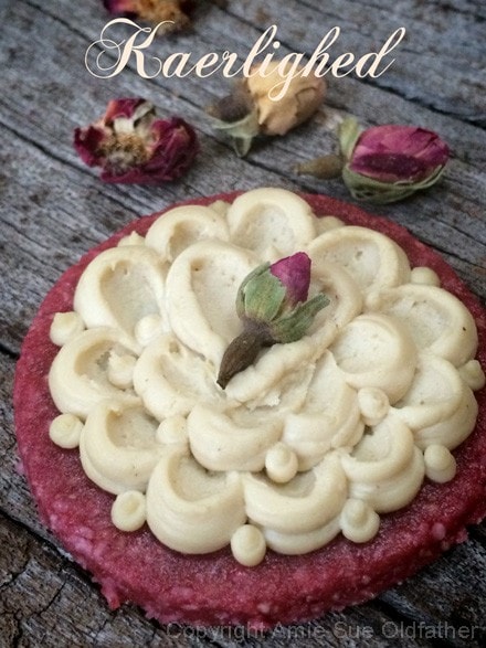 raw vegan Rosewater Sugar Cookie decorated with frosting on a wooden table