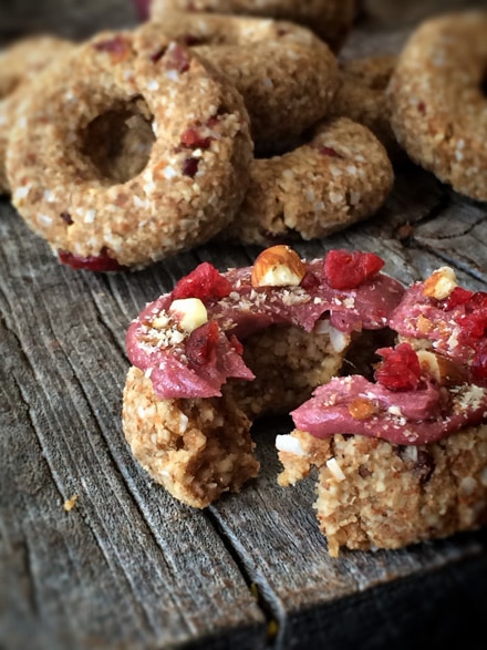 taking a bite from yummy Raw Cranberry Pumpkin Spice Donuts 