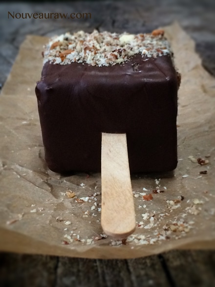 a close up of raw vegan Peanut Butter Banana Split on a Stick displayed on a wooden table