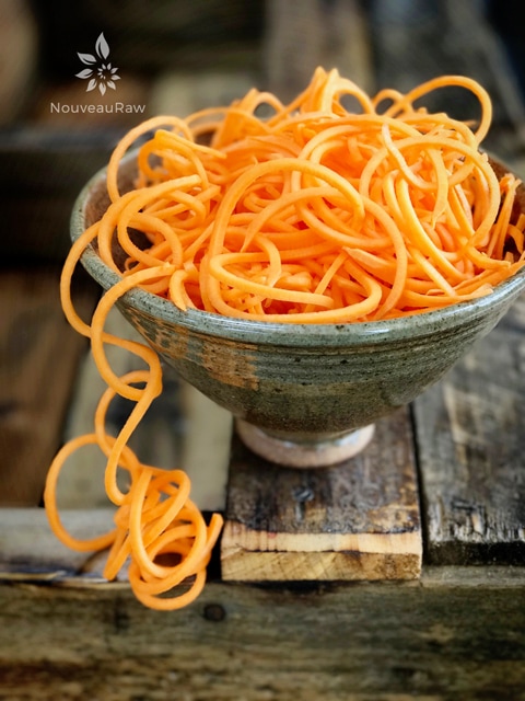 a close up of raw sweet potato noodles in a homemade ceramic bowl