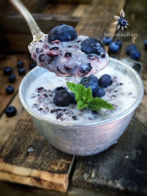 a spoonful of raw vegan Blueberry and Forbidden Black Rice Porridge served in a tin coffee mug