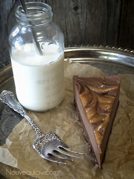 Rich, creamy, silky, smooth Raw Chocolate Peanut Butter Truffle Cream Pie with a jar of homemade nut milk, ready to eat