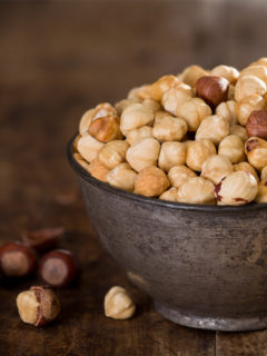 close up of raw hazelnuts in bowl